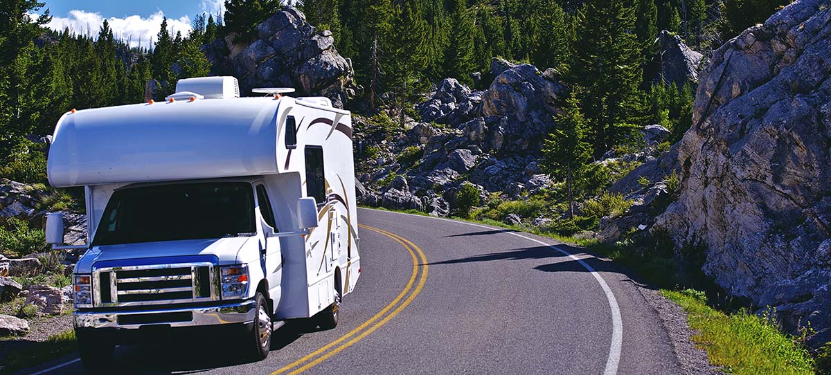 Recreation Vehicle driving down a mountain road after scheduling an RV Inspection 